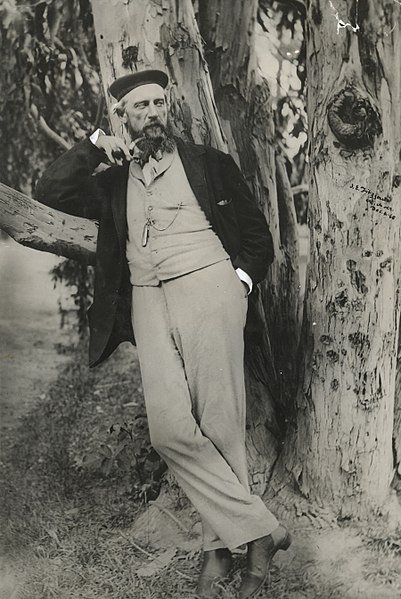 English: Standing portrait, of James Edward Fitzgerld leaning against a tree. He wears a suit and a beret and holds a tobacco pipe. Photograph taken in Christchurch on 4 December 1868, by Dr Albert Charles Barker. Making New Zealand caption reads: "James Edward Fitzgerald, who was associated with the colonisation of Canterbury. As editor of the 'Lyttelton Times' and later of 'The Press', and superintendent of Canterbury, Fitzgerald did important work for the young province. His later career was marked by diverse activities. In this photograph Fitzgerald is wearing a fashionable smoking cap and jacket. His well cut suit of a light material, lapelled waistcoat, and elastic-sided boots show the characteristic dress of a gentleman of the period."